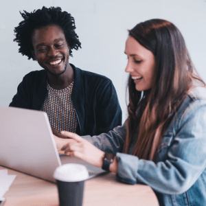 Woman and man smiling while working on the laptop